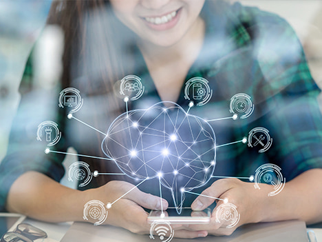 A woman holds a smartphone: above the device a networked brain with several icons.